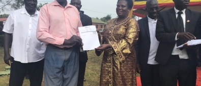 Hon. Amongi hands over PDM Voucher to one of the beneficiaries.