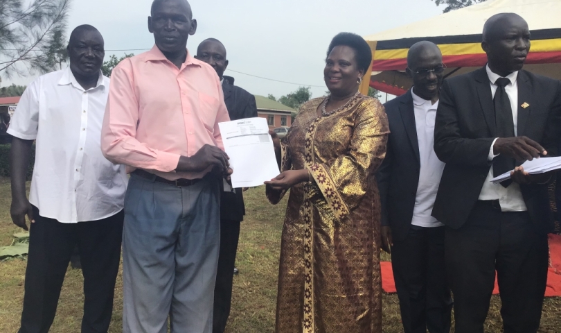Hon. Amongi hands over PDM Voucher to one of the beneficiaries.