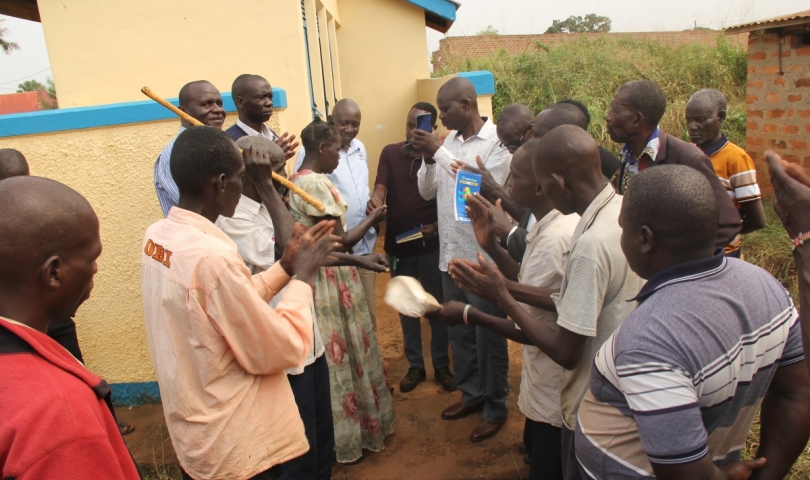 Assistant RDC Janol Okot handing over the Latrine keys to Chairperson Atek Central.